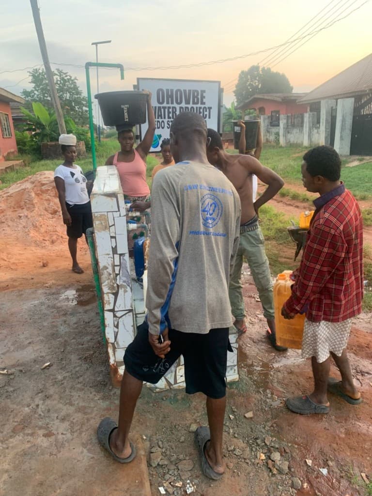 Residents gathering at the Ohovbe Water Project tap station