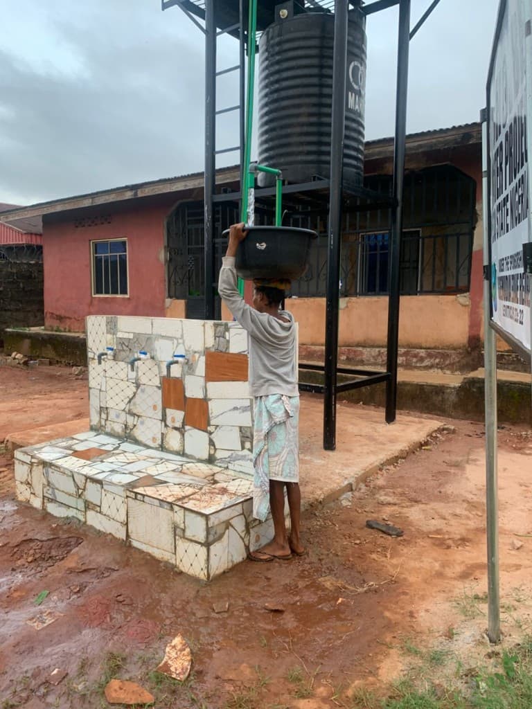 A resident collecting clean water at the Ohovbe borehole