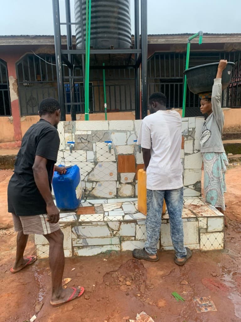 Community members filling jerrycans and basins at the Ohovbe taps